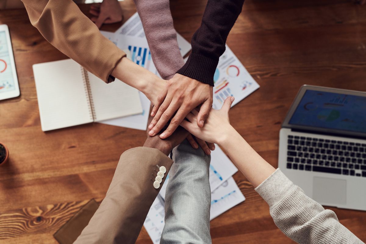 Equipe unindo as mãos sobre documentos e gráficos