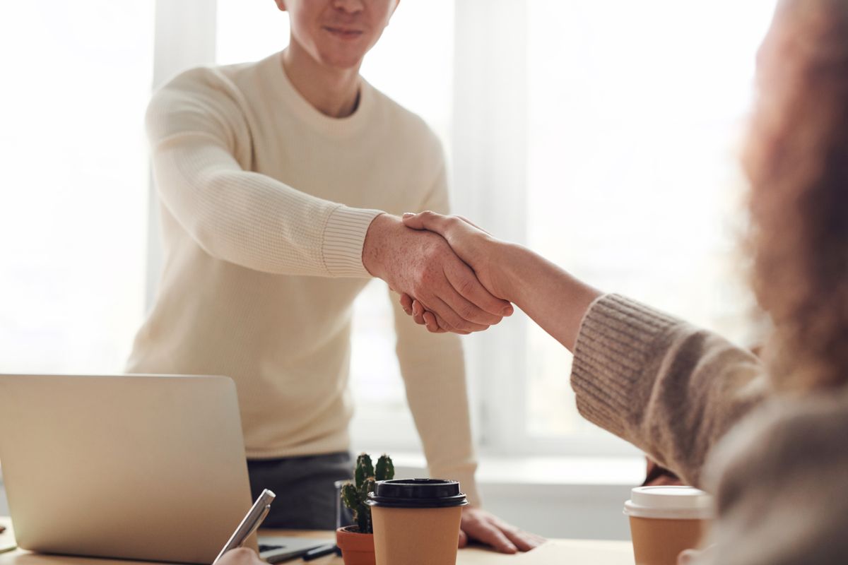 Duas pessoas se cumprimentando durante uma reunião de negócios