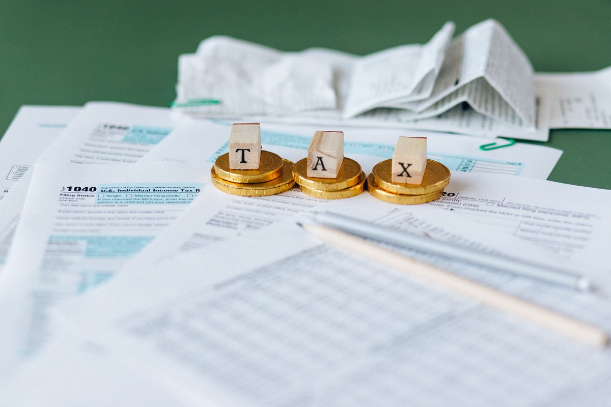 Documentos fiscais com moedas e a palavra tax